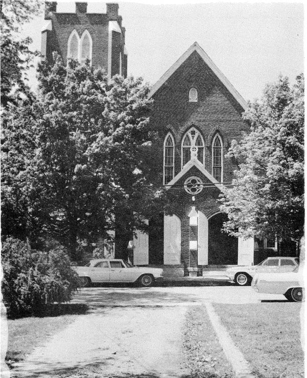 Historic black-and-white photo of Franklin First United Methodist Church, a Gothic brick church with pointed windows and a bell tower, with vintage cars parked out front