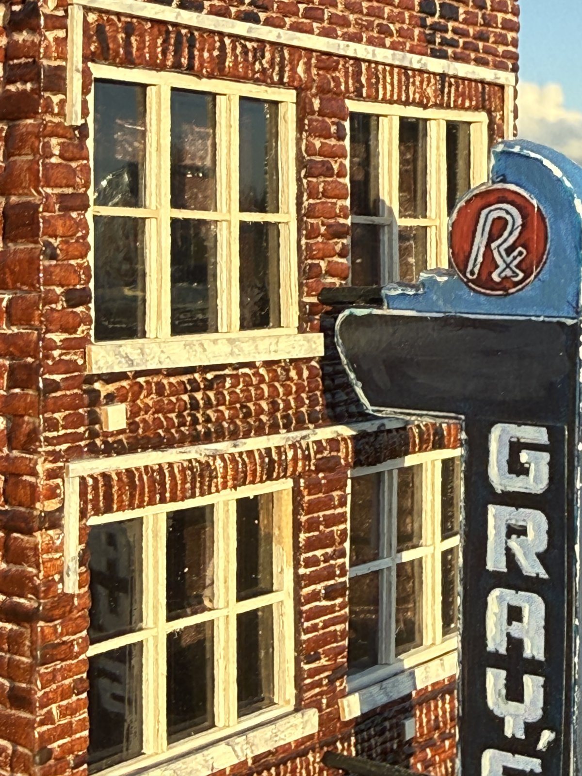 Close-up of the Gray's on Main miniature's windows, brickwork, and Rx sign