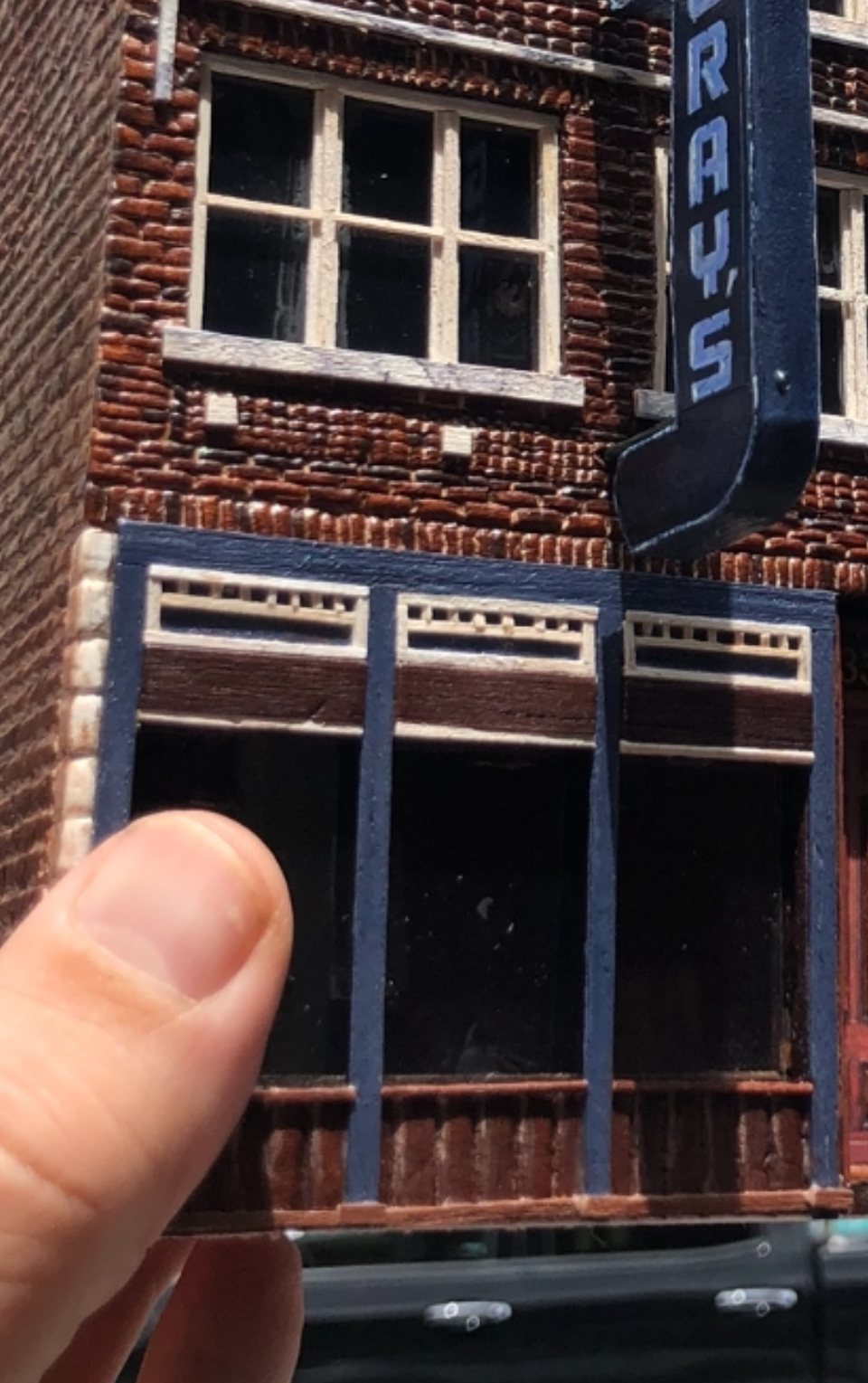 Close-up of the hand-painted storefront and brick detail on the Gray's on Main miniature