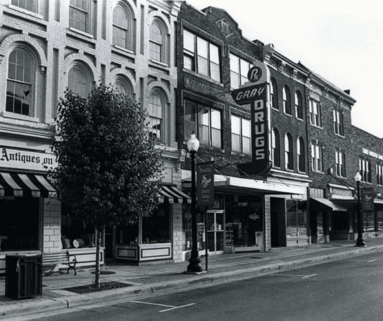 Historic black-and-white photo of Franklin's Main Street with the vertical Gray Drugs sign on the Victorian storefront