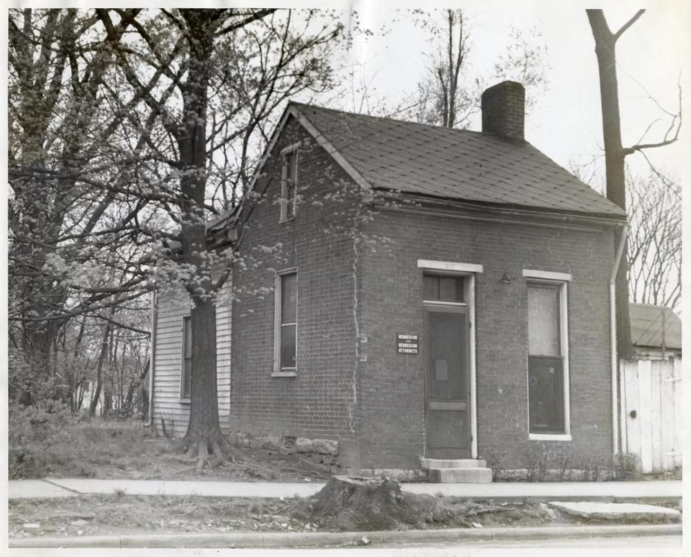 Historic black-and-white photo of the McPhail-Cliffe Office, a small brick building in Franklin, Tennessee, with a Henderson Attorneys sign by the door