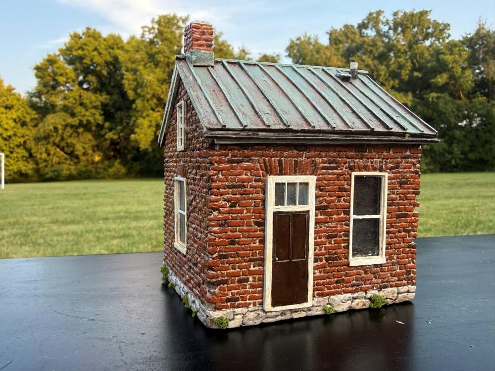 McPhail House miniature, front view with the door and windows, outdoors on a sunny day