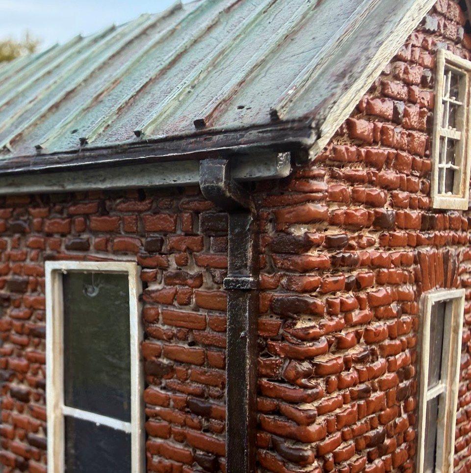 Close-up of the McPhail House miniature's metal roof, gutter and brick walls
